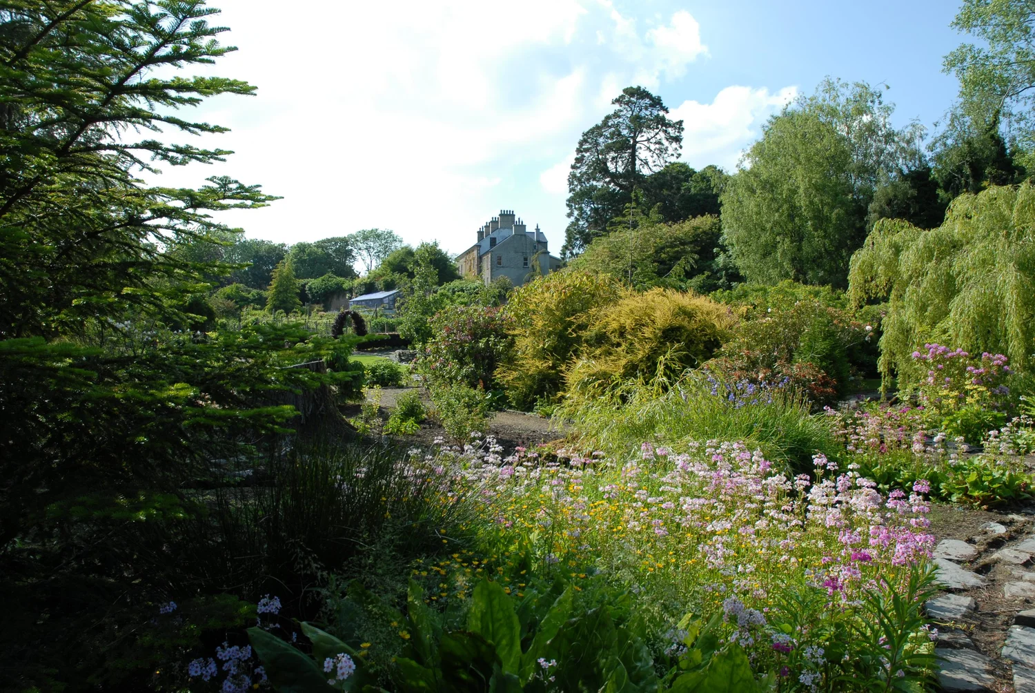 Spring flowers along the garden paths with Dunmore House beyond